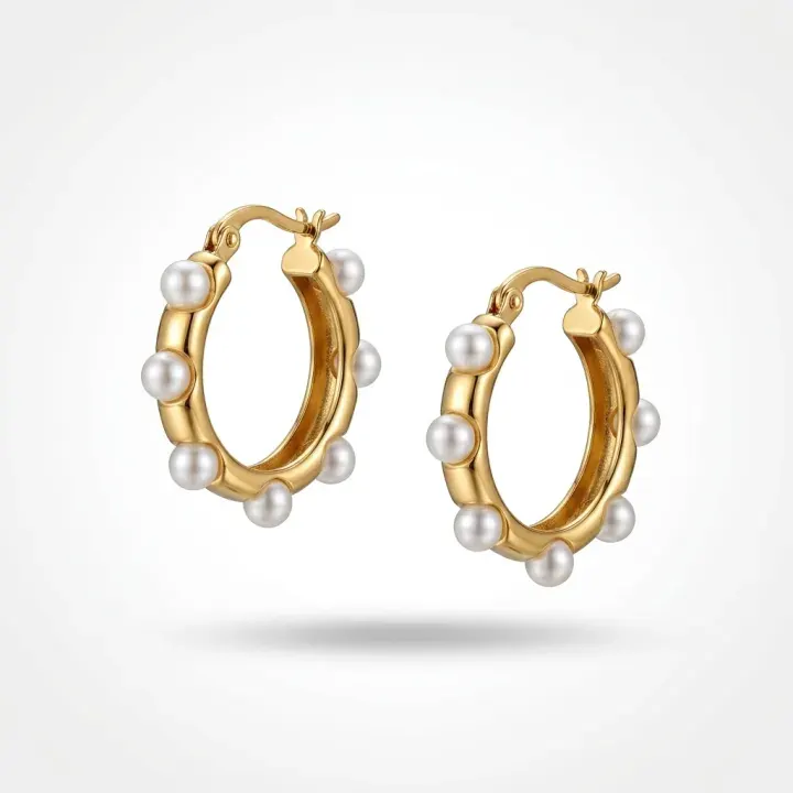 Gold and pearl hoops floating above a soft shadow on white.