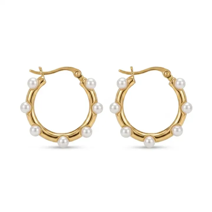 Gold and pearl hoop earrings on a seamless white background.