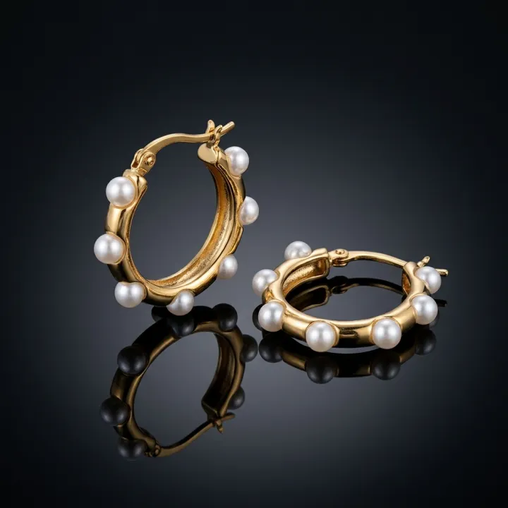 An editorial still life of jewellery resting on a reflective wet surface.